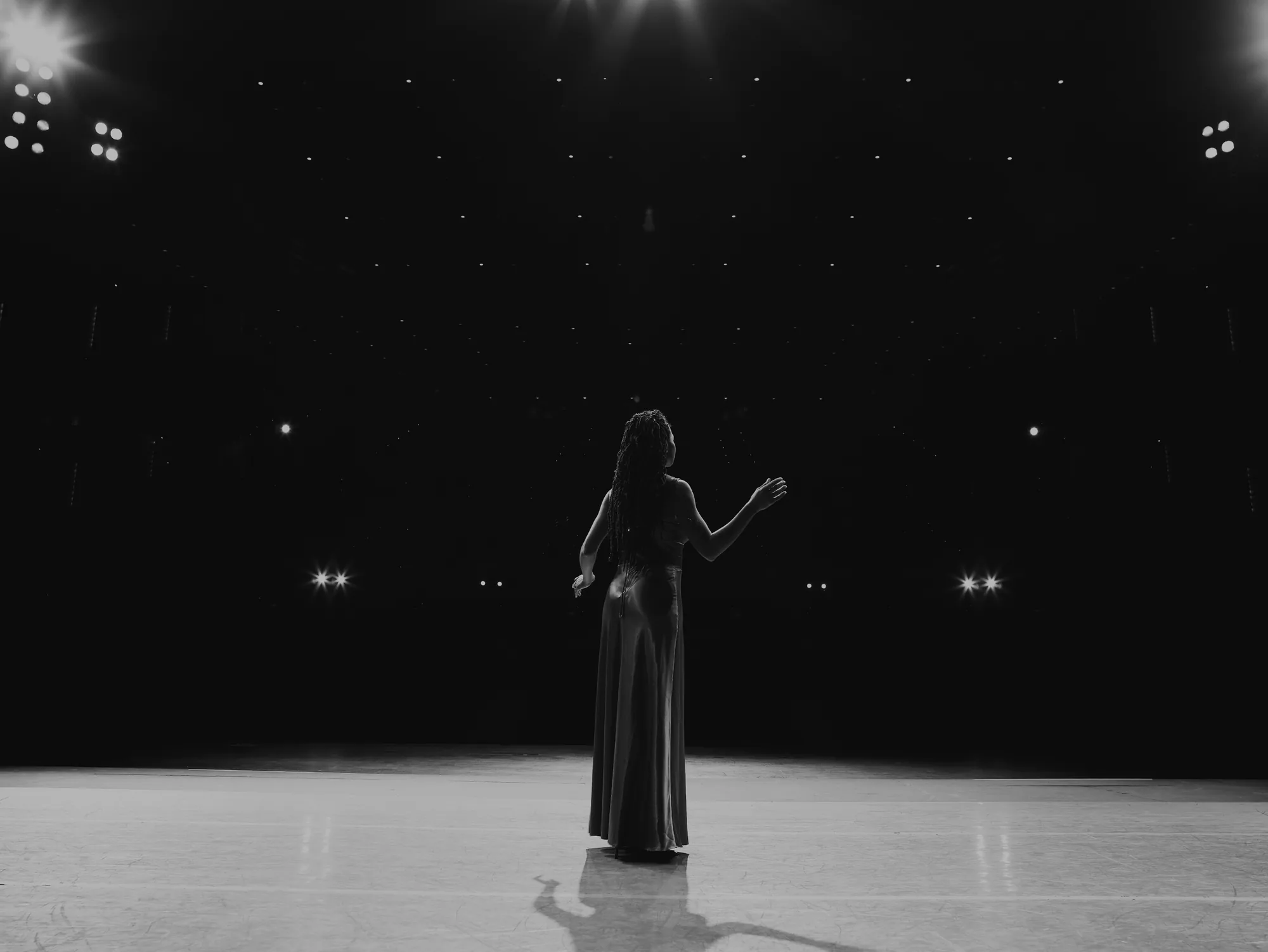 Black and white photo of a female opera singer performing on stage.